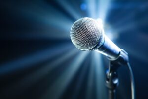 a microphone in a stand with a background halo of lights around it.